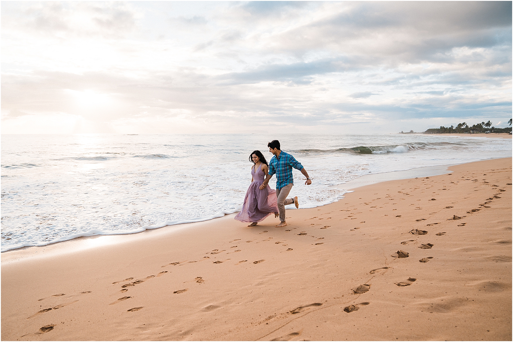 couple running on the beach together in Kauai