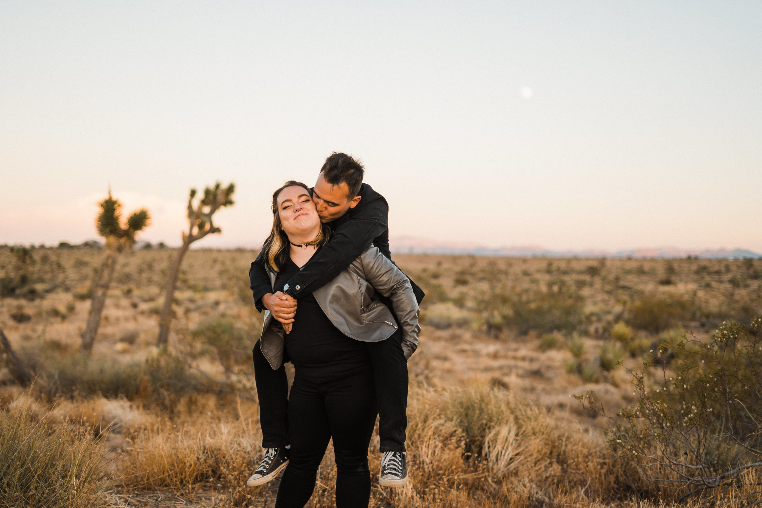 Fun quirky couple piggy back ride in Joshua Tree