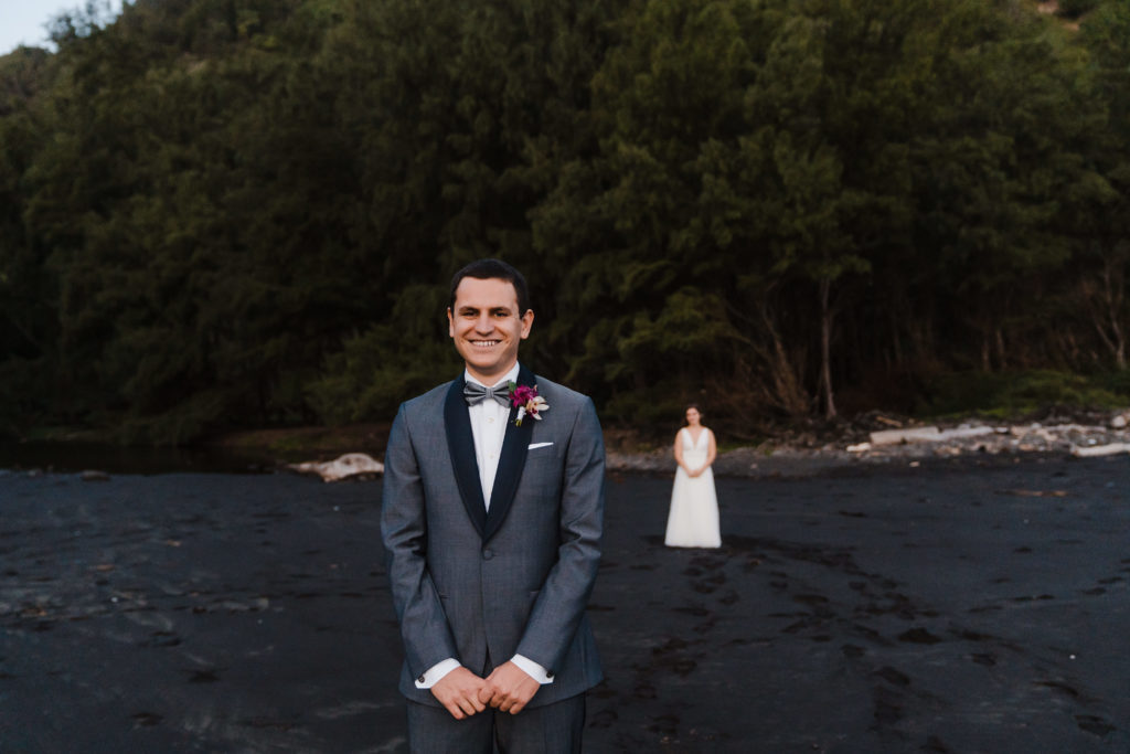 bride and groom first look on black sand beach