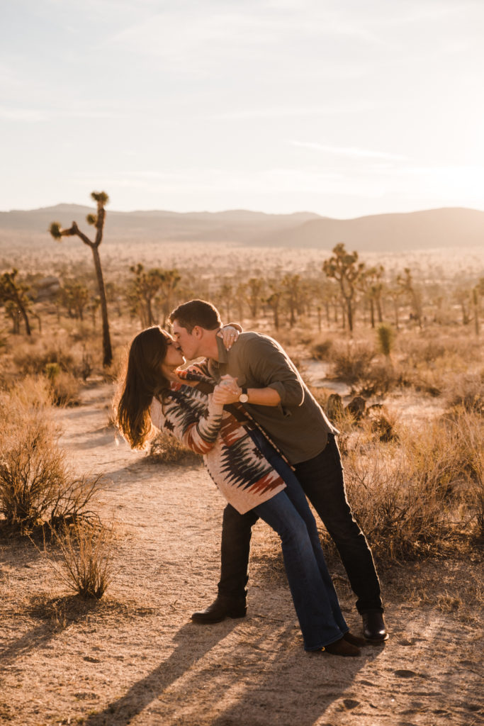 Couple dancing and doing a dip pose engagement pictures in the desert