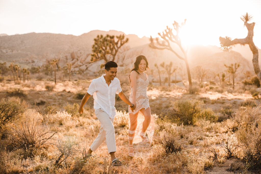 playful couple running in hidden valley joshua tree